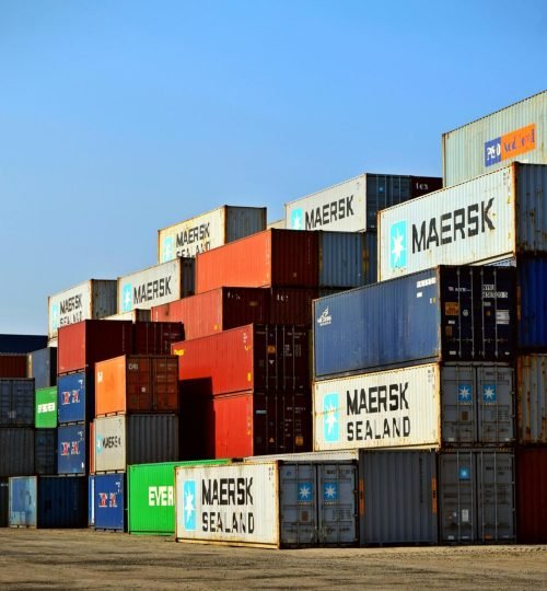 Colorful stacked shipping containers at a port exemplify global logistics.